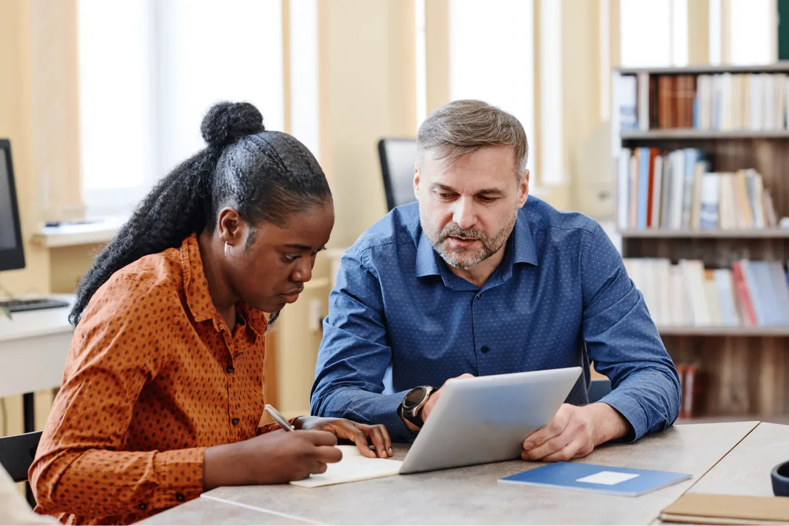 Formateur accompagnant une apprenante devant un ordinateur